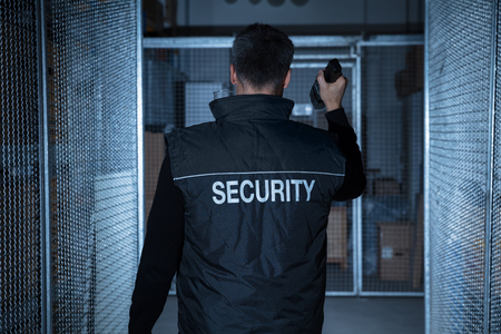 Mitarbeiter von Black Guard Security in Sicherheitsweste bei einer Kontrolle mit Taschenlampe